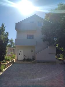 a white house with a bike parked in front of it at Apartman Villeto in Stari Grad