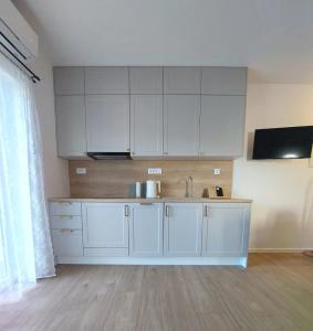 a kitchen with white cabinets and a sink at Apartman Villeto in Stari Grad