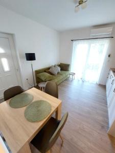 a living room with a table and a couch at Apartman Villeto in Stari Grad
