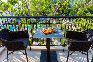 a plate of fruit on a table on a balcony at Boutique hotel Ruzmarin SPA & Garden by Aycon in Budva