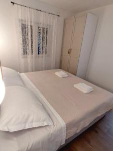 two beds in a small bedroom with a window at Apartman Villeto in Stari Grad