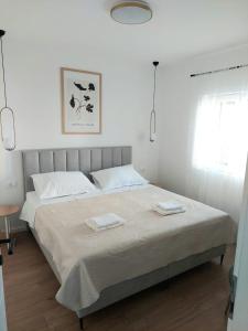 a bedroom with a bed with two towels on it at Apartman Villeto in Stari Grad