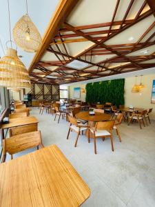 a dining room with wooden tables and chairs at MAKIA BEACH - Alto Padrão - PRAIA MURO ALTO - Porto de Galinhas in Porto De Galinhas