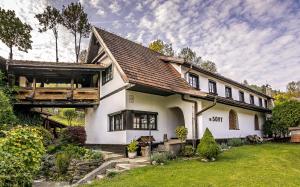 a large white house with a roof at Penzion U Sovy in Dolný Kubín