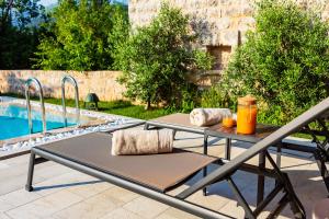 a table and chairs next to a swimming pool at Boutique hotel Ruzmarin SPA & Garden by Aycon in Budva