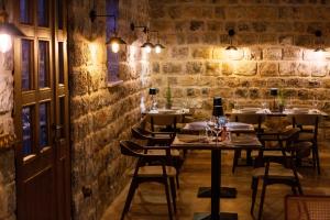 a restaurant with tables and chairs in a brick wall at Boutique hotel Ruzmarin SPA & Garden by Aycon in Budva