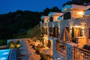 a villa with a swimming pool at night at Boutique hotel Ruzmarin SPA & Garden by Aycon in Budva