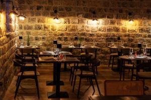 a restaurant with tables and chairs in a stone wall at Boutique hotel Ruzmarin SPA & Garden by Aycon in Budva