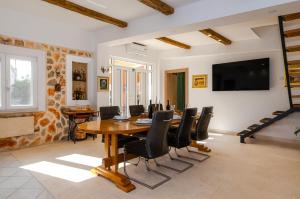 a dining room with a wooden table and black chairs at Villa Nika in Konjevrate