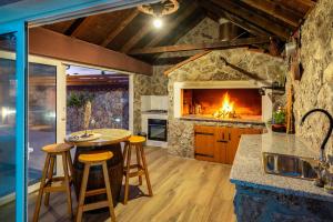 a kitchen with a fireplace and a table with stools at Villa Nika in Konjevrate