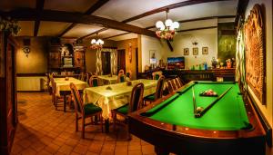 a pool table in a restaurant with tables and chairs at Penzion U Sovy in Dolný Kubín