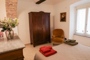 una camera da letto con un letto, una sedia e un tavolo di Apartment Corso Alfieri from 1700s AC & Queen Bed ad Asti