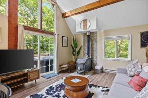 InwoodにあるHot Tub Chalet-Fire Pit Grill Stream & Big Yardのリビングルーム(テレビ、ソファ付)