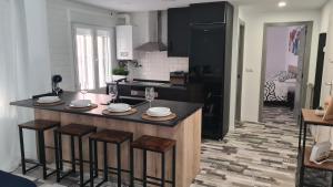 a kitchen with a counter with stools in it at Apartamento Soria Calaverón in Soria