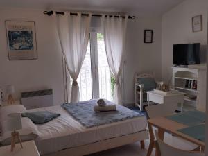 a bedroom with a bed and a large window at Résidence des Abeilles in Avignon