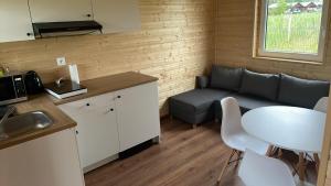 a kitchen and living room with a couch and a table at Wicie - Domki u Anioła in Wicie