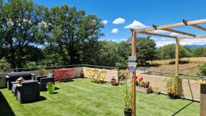 a garden with chairs and a pergola at Les 3 Chênes in Puechredon