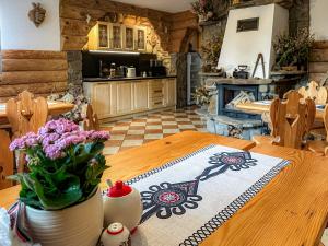 a kitchen with a wooden table with flowers on it at Noclegi u Masnych in Witów