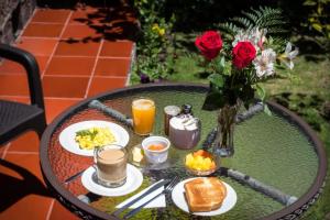 a table with plates of food and a vase of roses at Casa del Arupo B&B in Quito