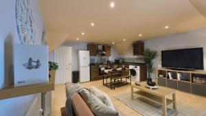 a large living room with a couch and a kitchen at Group Bookings: Up To 30 Guests Across 5 Spacious Flats! Keyless Access Free Wifi & Parking in Birmingham