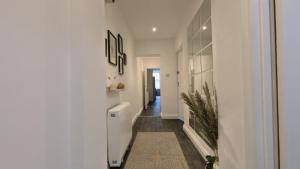 a hallway of a home with white walls at Group Bookings: Up To 30 Guests Across 5 Spacious Flats! Keyless Access Free Wifi & Parking in Birmingham