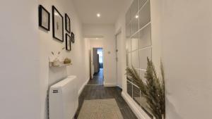 a hallway of a home with white walls and wooden floors at Group Bookings: Up To 30 Guests Across 5 Spacious Flats! Keyless Access Free Wifi & Parking in Birmingham