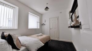 a white bedroom with two beds and a window at Group Bookings: Up To 30 Guests Across 5 Spacious Flats! Keyless Access Free Wifi & Parking in Birmingham