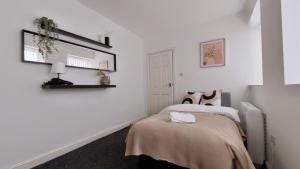 a bedroom with white walls and a bed with a blanket at Group Bookings: Up To 30 Guests Across 5 Spacious Flats! Keyless Access Free Wifi & Parking in Birmingham