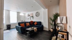 a living room with a blue couch and a table at Group Bookings: Up To 30 Guests Across 5 Spacious Flats! Keyless Access Free Wifi & Parking in Birmingham