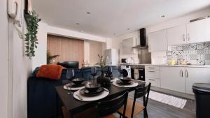 a kitchen and living room with a table and chairs at Group Bookings: Up To 30 Guests Across 5 Spacious Flats! Keyless Access Free Wifi & Parking in Birmingham
