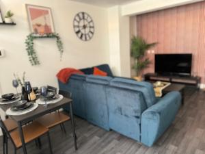 a living room with a blue couch and a table at Group Bookings: Up To 30 Guests Across 5 Spacious Flats! Keyless Access Free Wifi & Parking in Birmingham