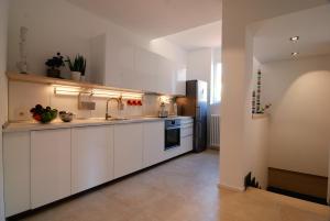 a kitchen with white cabinets and a sink and a refrigerator at Isola Libera in Milan