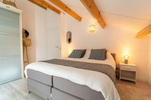 a bedroom with a large bed with two pillows at Veermansplaat 27 - Noordzeepark Ouddorp in Ouddorp