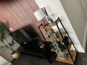 a room with a desk with a television and a plant at Group Bookings: Up To 30 Guests Across 5 Spacious Flats! Keyless Access Free Wifi & Parking in Birmingham