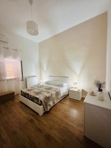una camera bianca con letto e pavimenti in legno di La Rosa di Candy a Brindisi