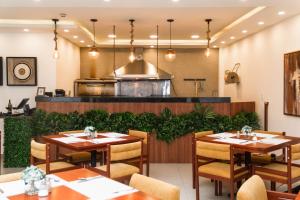 a restaurant with tables and chairs and a kitchen at REEC Latacunga by Oro Verde Hotels in Latacunga