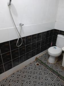 a bathroom with a toilet and a shower at Dian Rana Bungalow Lampuuk in Lamgire