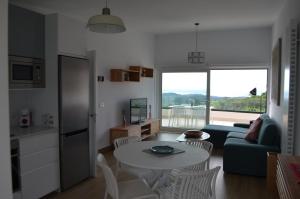 eine Küche und ein Wohnzimmer mit einem Tisch und einem Sofa in der Unterkunft MIRADOR PLAYA DE OYAMBRE-vista al mar y jardín in Canales