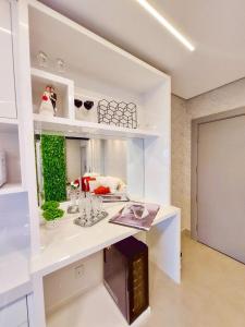 eine Küche mit einer weißen Theke mit einem Regal in der Unterkunft Luxury Collection - Loft com Banheira 33º Ed Vertigo in Campo Grande + 23 Fotos