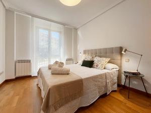 ein Schlafzimmer mit einem großen Bett und einem großen Fenster in der Unterkunft VUT Plaza Fontana in Salamanca