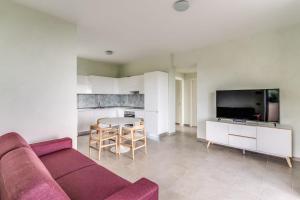 a living room with a couch and a table and a tv at Le Arcate Sea La Vie by Feeling Italy in Massa Lubrense