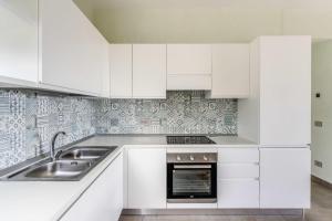 a white kitchen with white cabinets and a sink at Le Arcate Sea La Vie by Feeling Italy in Massa Lubrense