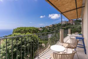 a balcony with a table and chairs and the ocean at Le Arcate Sea La Vie by Feeling Italy in Massa Lubrense
