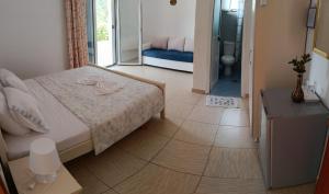a small bedroom with a bed and a bathroom at Penelope's Rooms in Dhërmi +35 photos