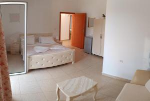 a bedroom with a bed and a mirror and a table at Penelope's Rooms in Dhërmi