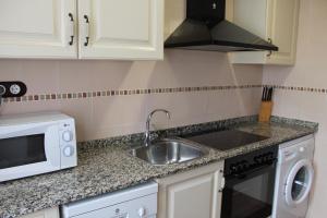 a kitchen with a sink and a microwave at Apartamentos Turísticos Pepe in Gea de Albarracín