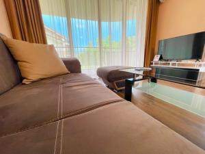 a living room with a couch and a flat screen tv at Long Sunny Holiday in Shkorpilovtsi
