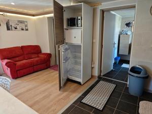 a living room with a red couch and a kitchen at Appartement Top entre mer et montagne in Thèzan-lès-Béziers