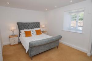 - une chambre dotée d'un lit avec des oreillers orange dans l'établissement The Hayloft, Sewerby, Bridlington, Wi-Fi & Parking, à Bridlington