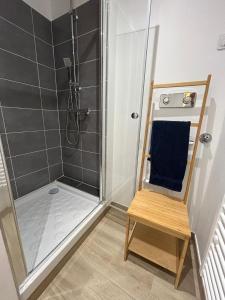 a shower with a blue towel and a wooden chair at Studio Siana in Chartres